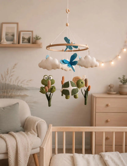 Felt baby mobile with frog and turtle hanging above crib – pond nursery decor