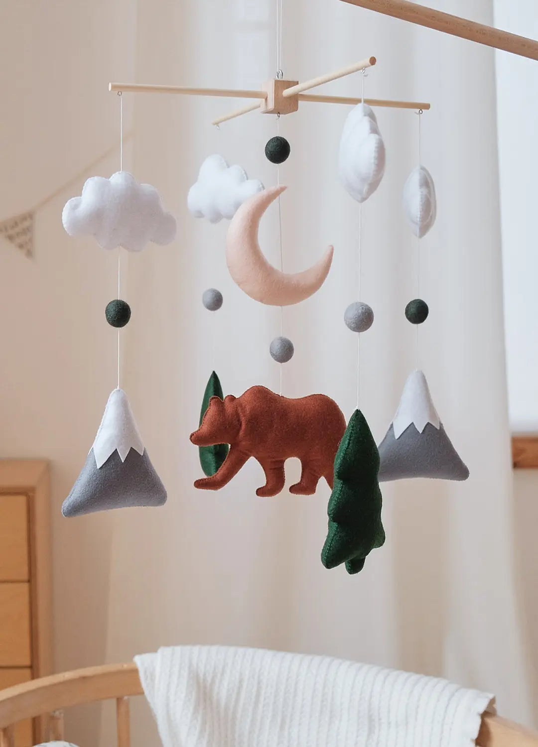 Felt bear baby mobile with snowcapped mountains, crescent moon, clouds and fir trees on wooden hanger