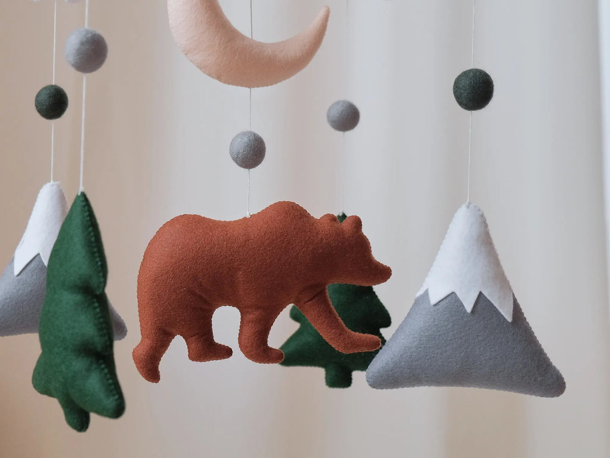 Felt bear mountain baby mobile with white clouds, crescent moon and fir trees on wooden cross hanger