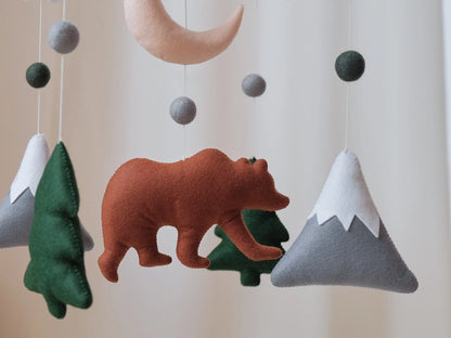 Felt bear mountain baby mobile with white clouds, crescent moon and fir trees on wooden cross hanger