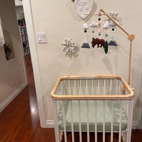 Woodland crib mobile with felt bear and mountains in green and white nursery