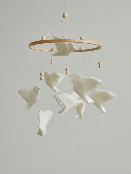 White felt animal mobile with layered flying birds, a natural wooden hoop and wood beads