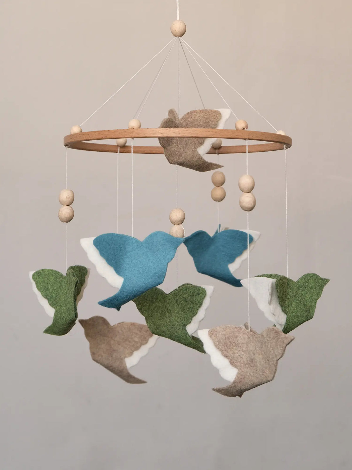 Woodland Mix flying bird mobile with blue, green and beige felt birds on a wooden hoop