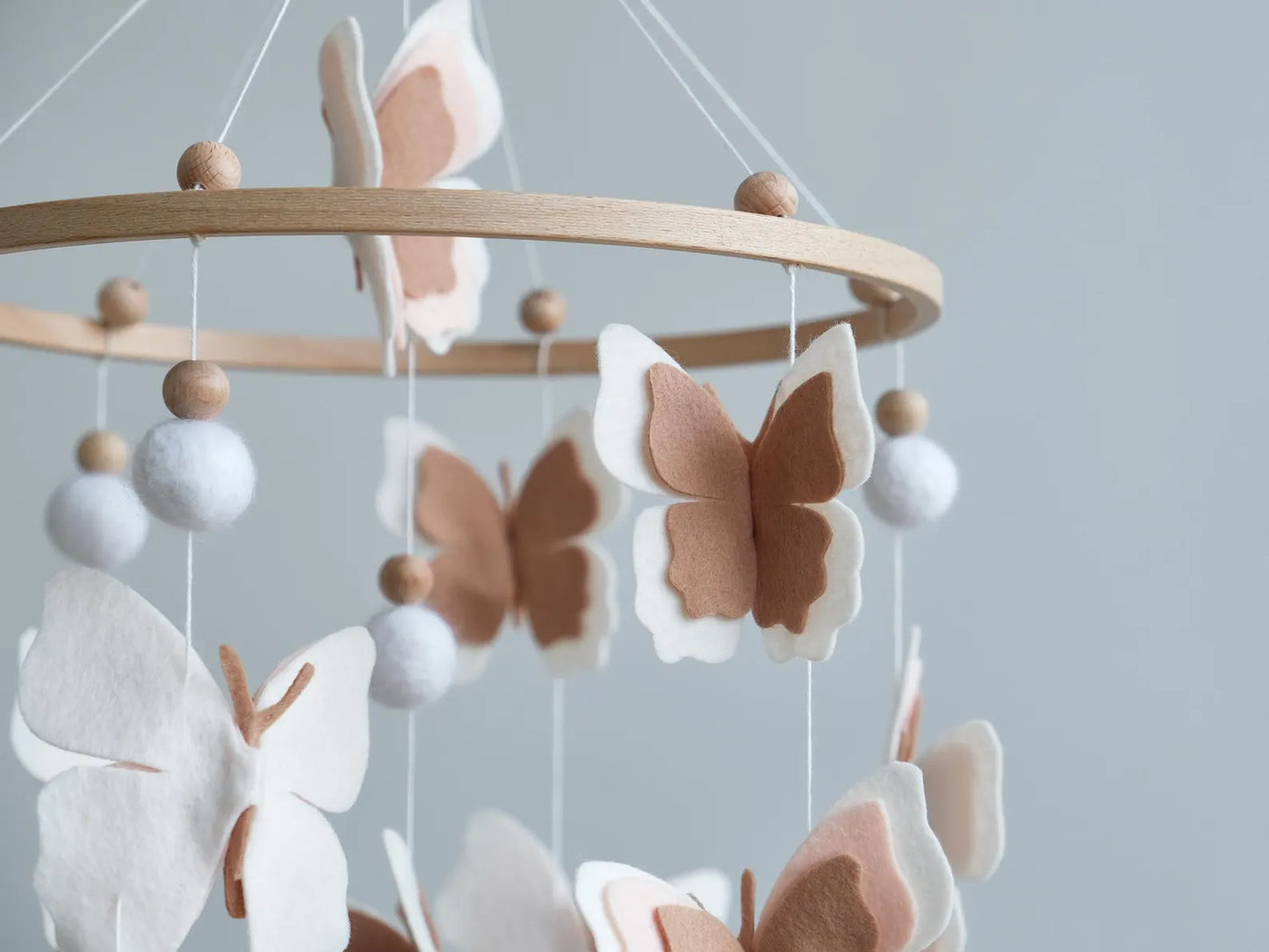 Felt blush butterfly closeup – white and brown layered wings on handmade baby mobile