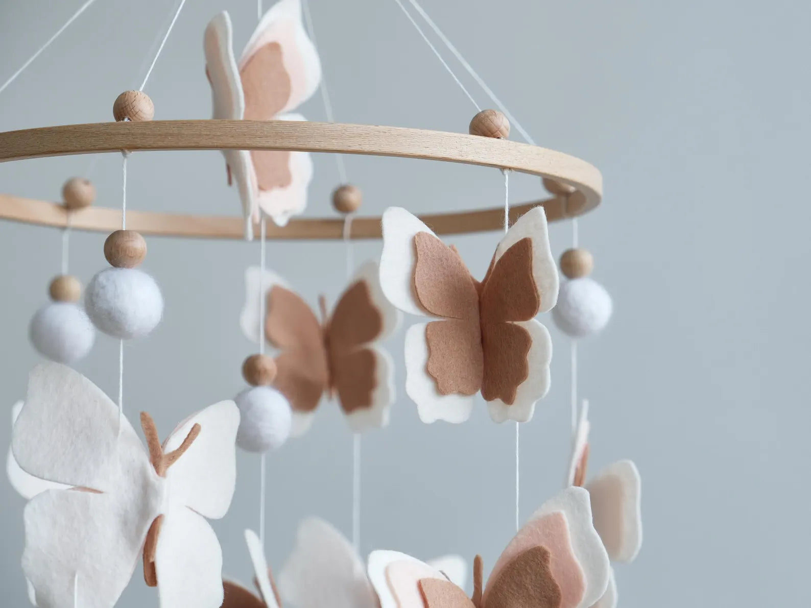 Felt blush butterfly closeup – white and brown layered wings on handmade baby mobile