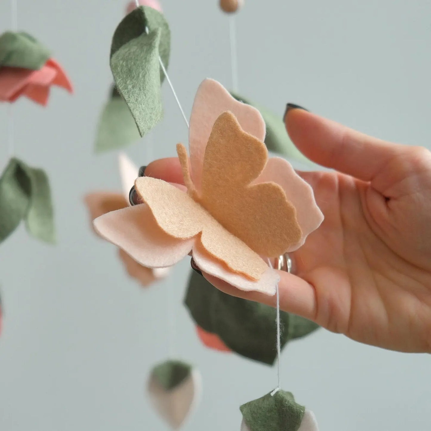 Felt butterfly closeup – handmade floral baby mobile detail in peach and pink