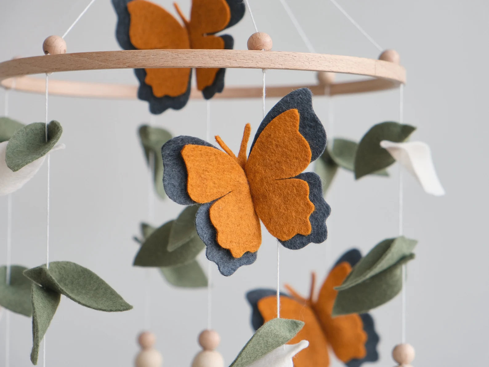 Felt monarch butterfly closeup – orange and charcoal wings on handmade baby mobile