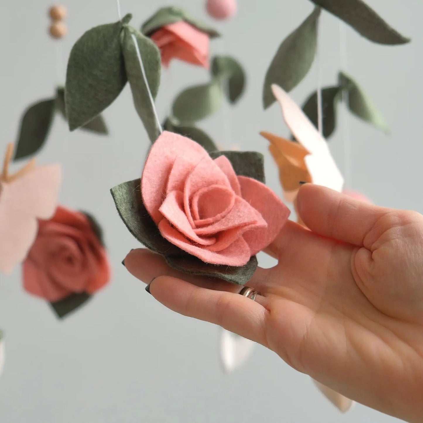 Felt rose closeup – handmade floral baby mobile detail in coral pink