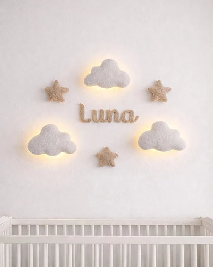 Nursery room with cloud and star wall decorations on a white wall above a crib.
