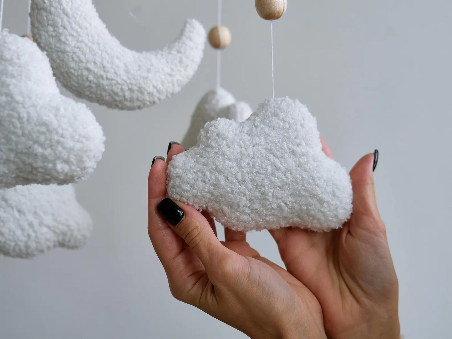 Close-up of handmade boucle cloud texture on soft baby mobile showing plush detail