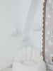 Handmade white boucle cloud night light glowing softly on a nursery wall
