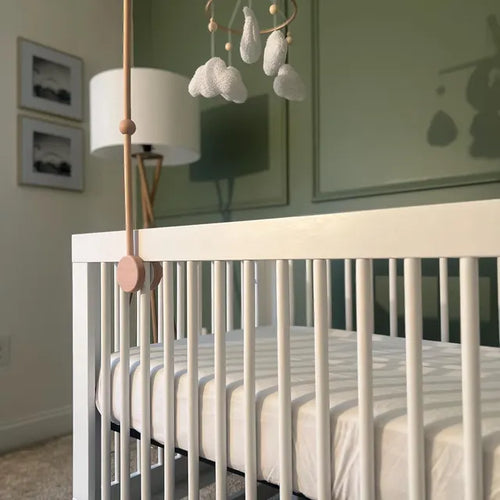 Customer photo of a white boucle cloud and moon baby mobile above a modern white crib