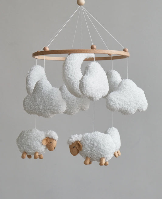 Soft lamb crib mobile with boucle clouds and moon, close-up of handmade nursery mobile