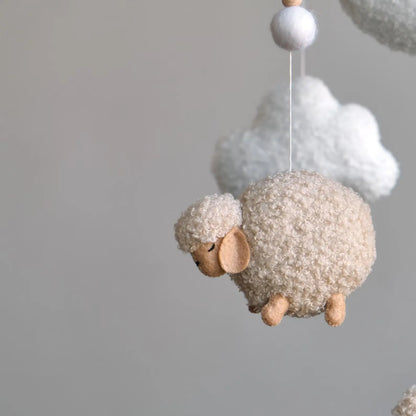 Close-up of handmade boucle sheep figure for baby mobile showing plush detail and felt face