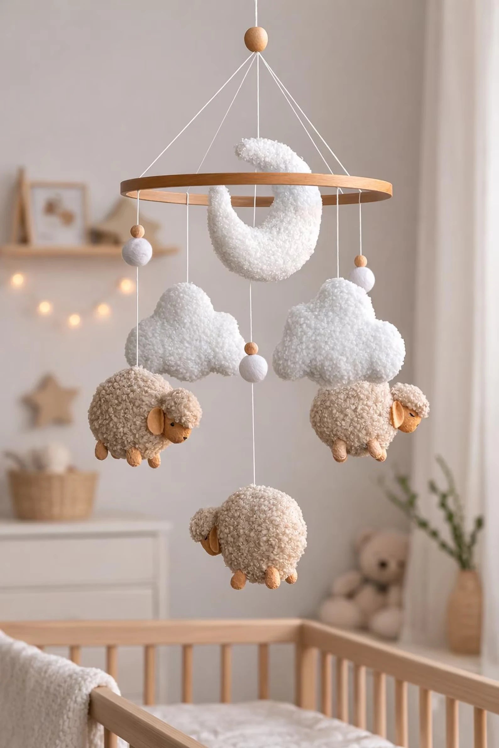 Soft baby mobile with beige boucle sheep and clouds above crib in cozy nursery