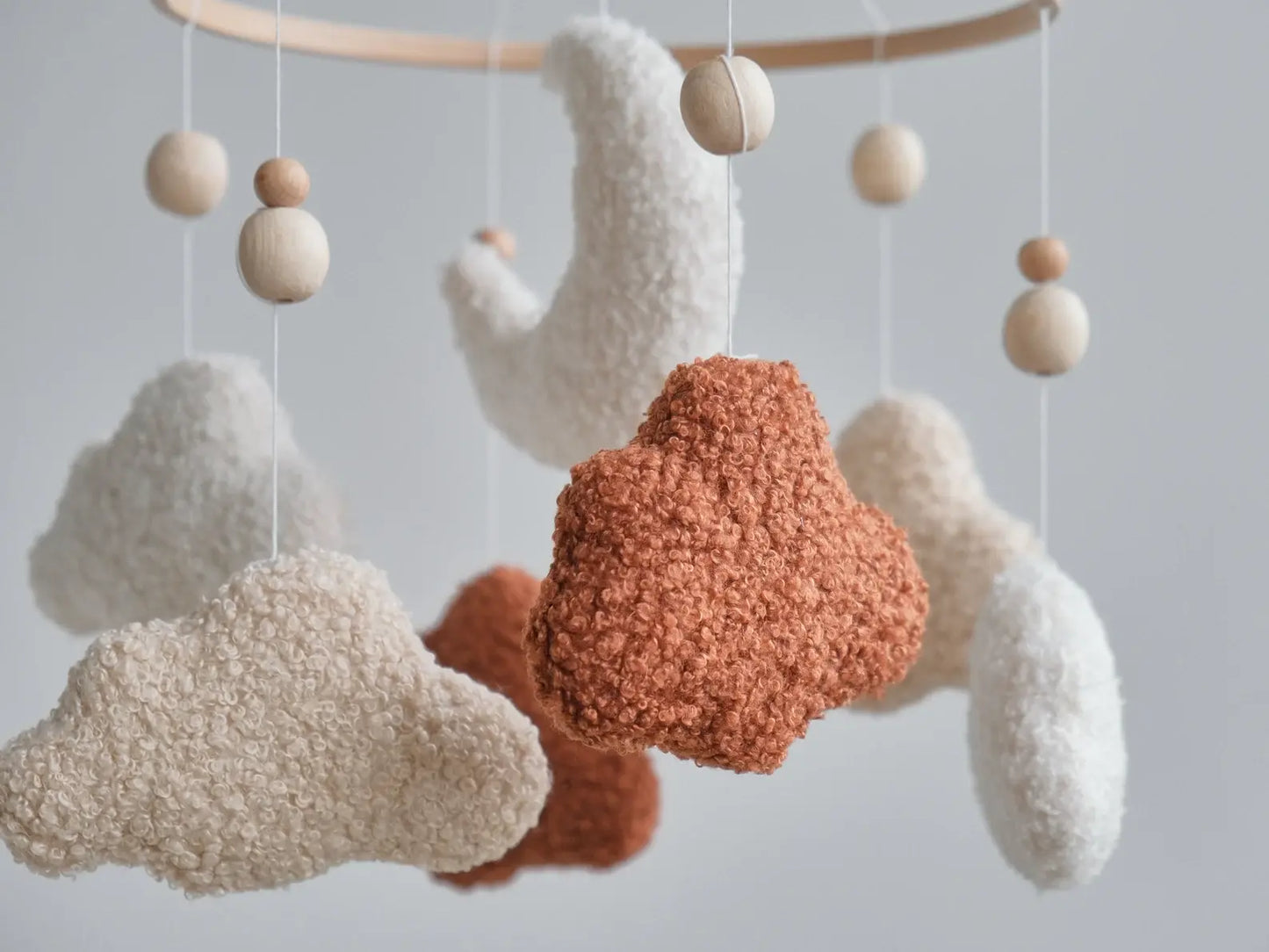 Close-up of boucle fabric texture on terracotta cream and beige cloud mobile