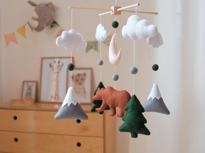 Woodland animal crib mobile with felt bear, mountains, fir trees and clouds for a gender-neutral nursery